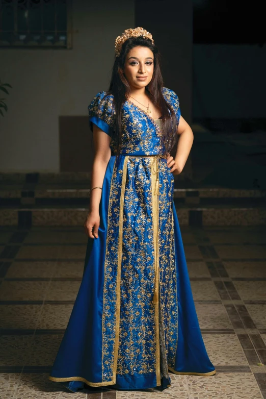 an african woman is standing in a blue gown