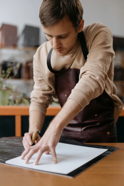 a man that is reaching for soing on top of a table