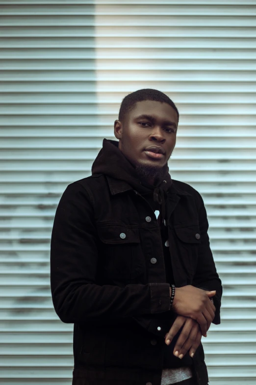 an african american man in black jacket standing and posing