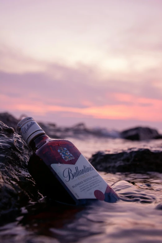 a bottle of wine in the ocean near rocks