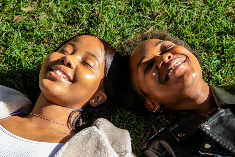 two people lying down in the grass together