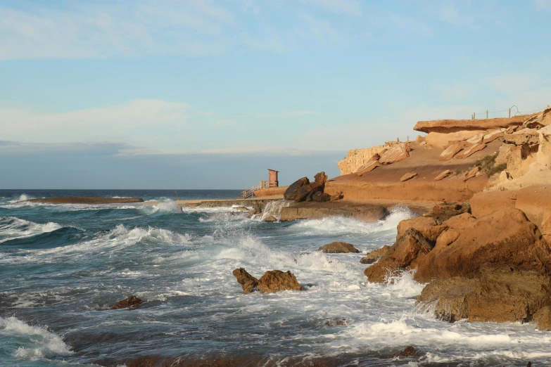 a rocky shoreline with rough waves on it