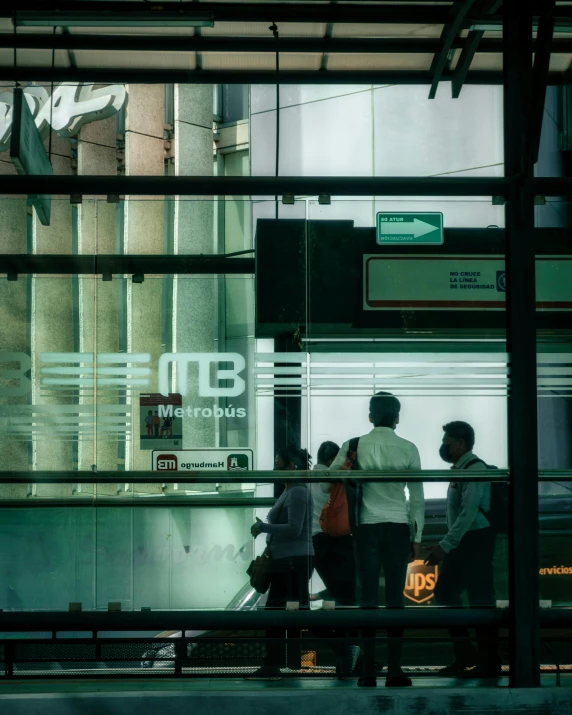 a group of people walking along a street next to tall buildings