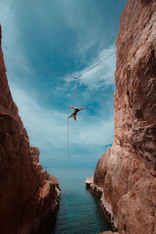 a man standing on rope above water