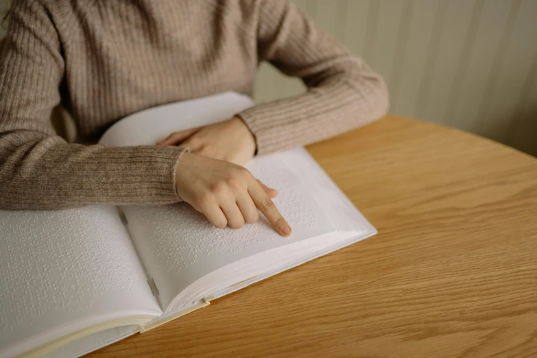 there is a person sitting at a table with an open book