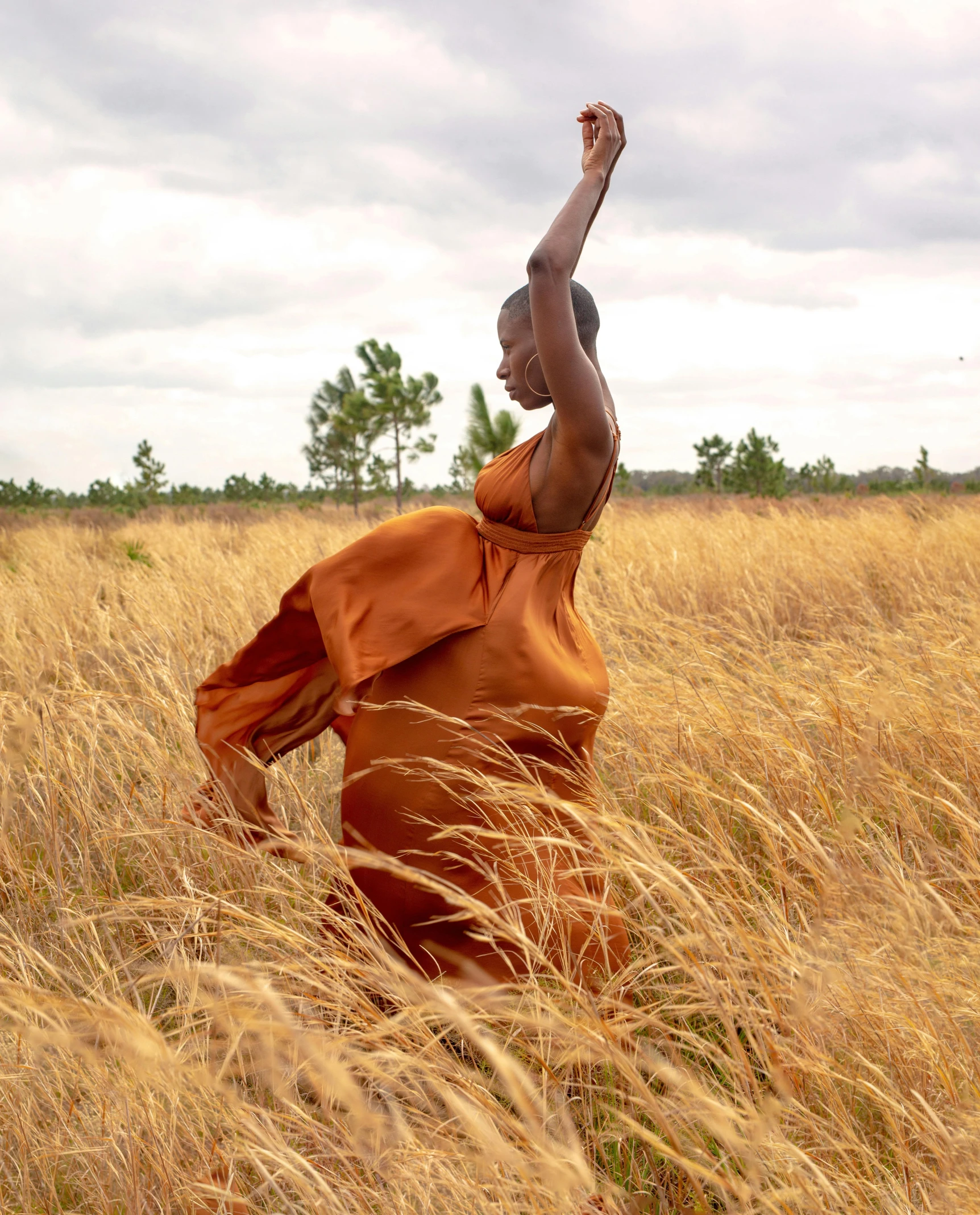 a person standing in tall grass with their arms up