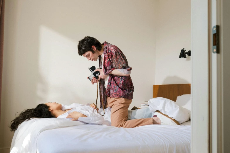 a woman laying on her bed while a man pographs