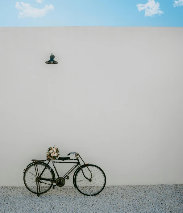 a bicycle leaning against the wall in front of an artistic po