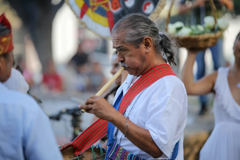 man carrying a basket with food and a stick in hand