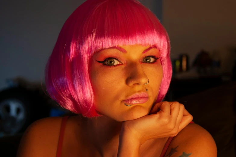 a women with tattoos on her neck and pink hair