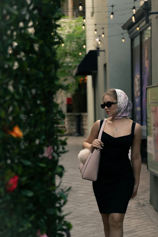 a woman in black dress and bonnet walking down street