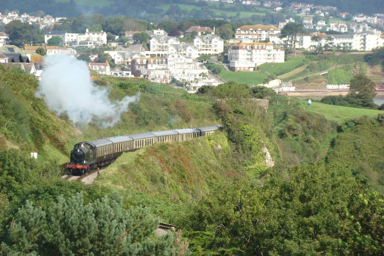 a train riding down some tracks through the hills