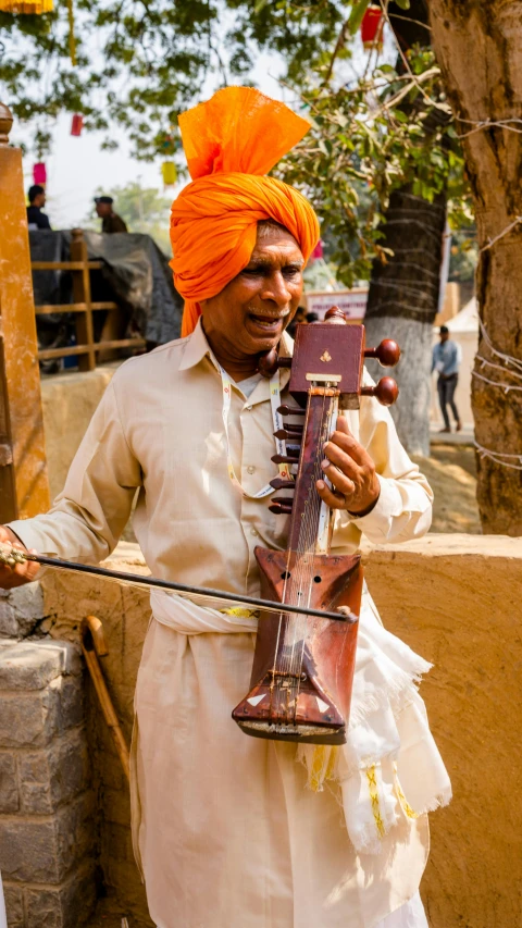 a man is holding a musical instrument in his left hand