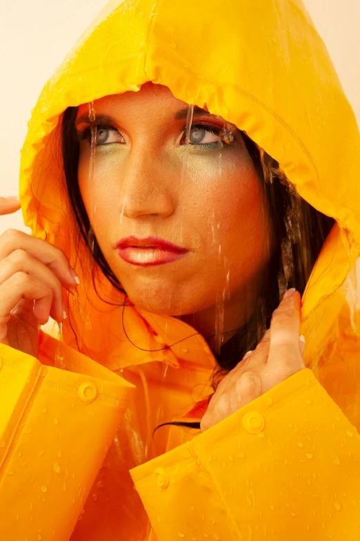 a young woman poses in a yellow rain coat