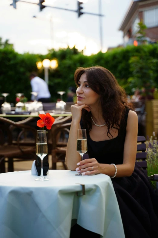 a woman is sitting outside by herself while sitting at a table