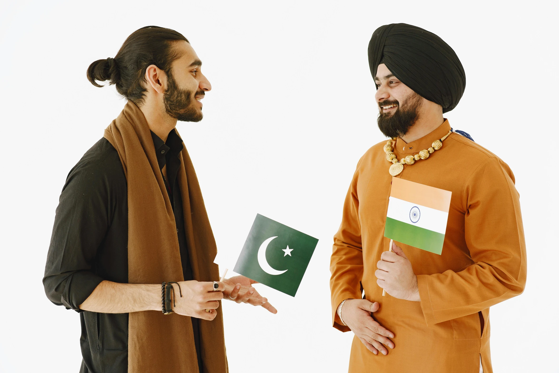 two men are wearing national clothes and holding books