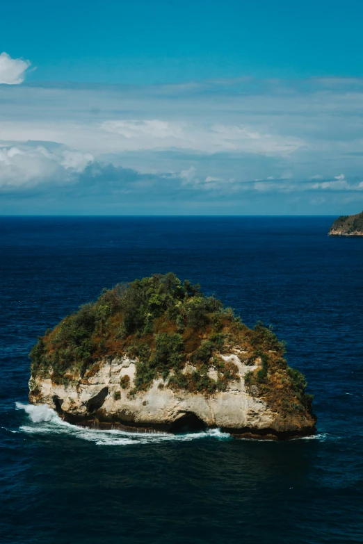 a boat sailing through an island with a rocky head
