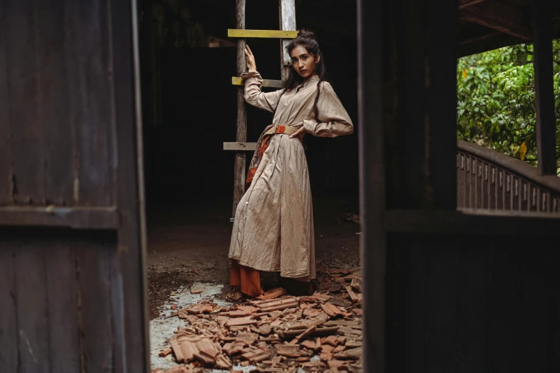 a woman wearing a long brown dress is holding a sword