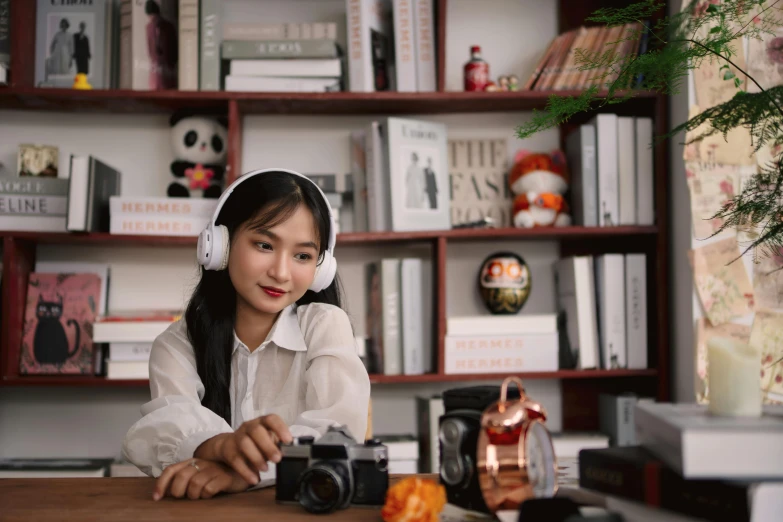 a woman with headphones sits at a desk