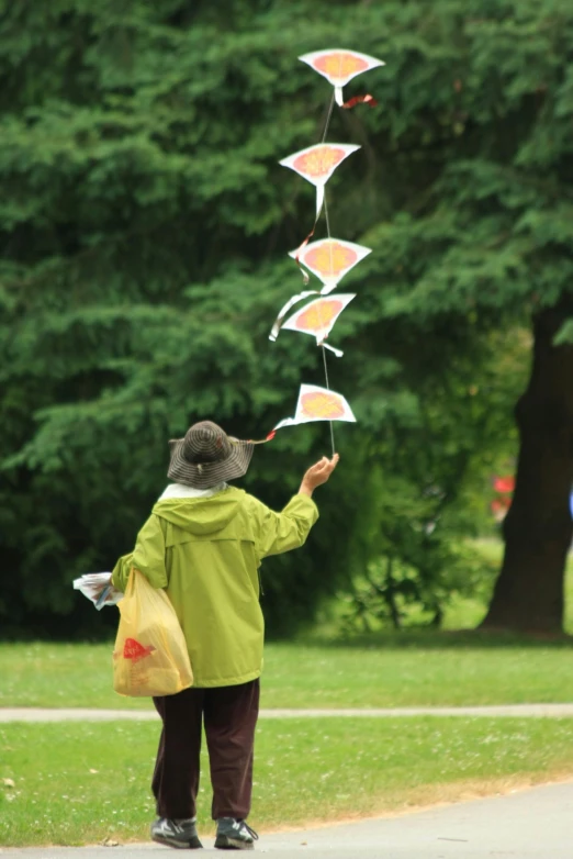 woman standing on the street trying to get string down with kites