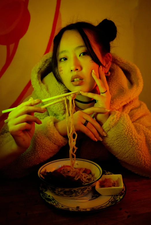 an asian woman eating from chopsticks at a dinner table