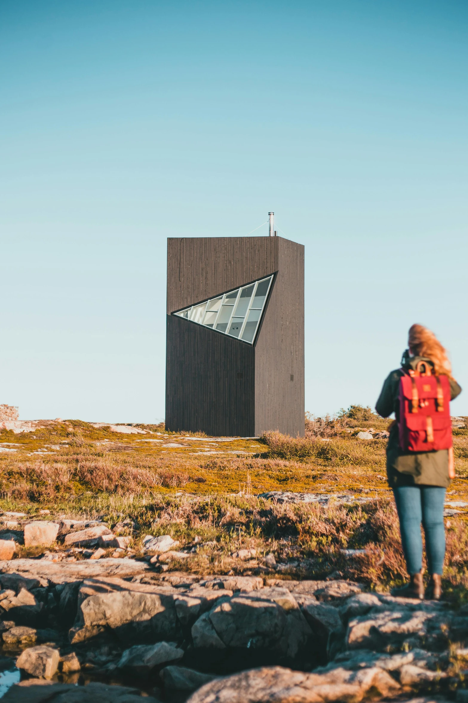 a woman is in the grass on a hill