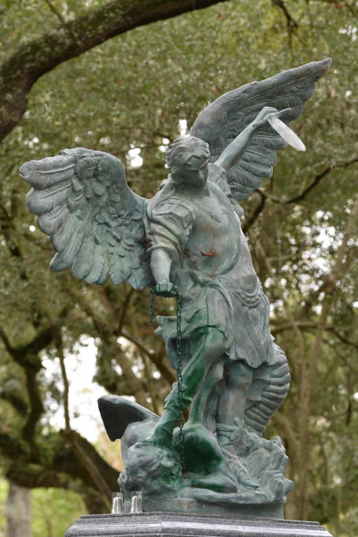 a statue in the park with its wings spread out