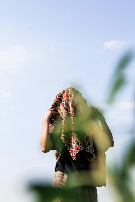 a person is holding his head near her face and there are some trees