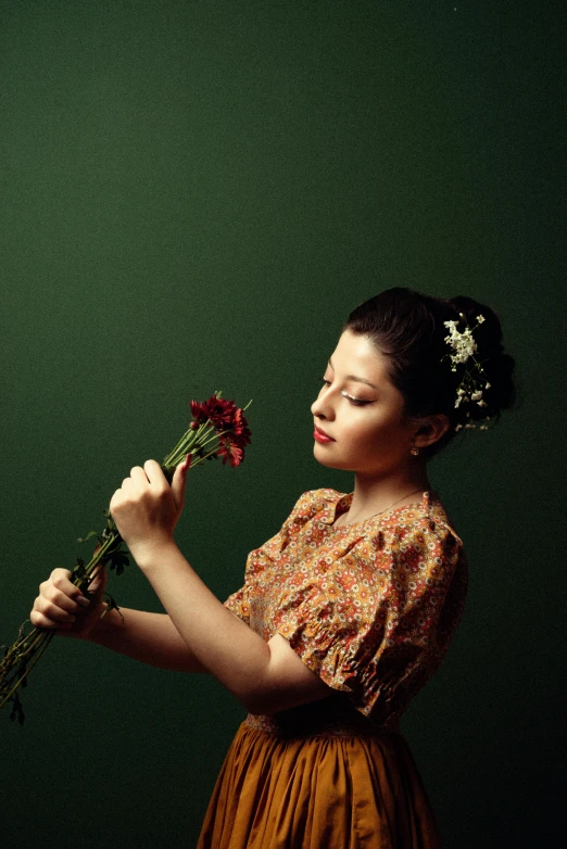 a woman holding onto some flowers while posing for a po