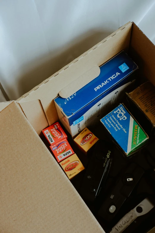 the open box contains various items like razor, toothpaste, tooth paste, pencil and a pair of scissors