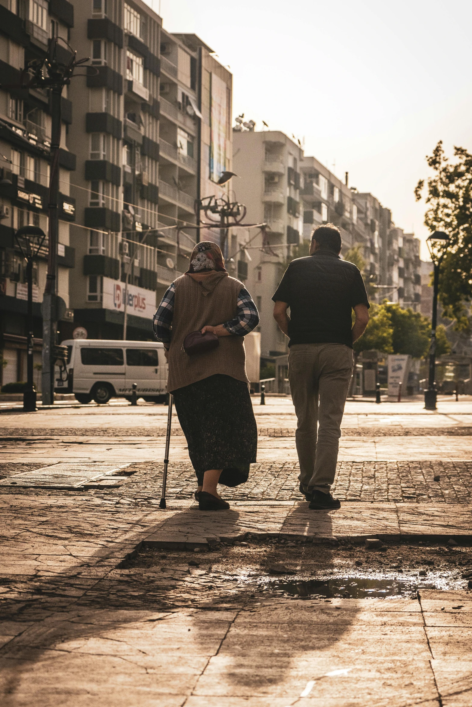 people walking down the road carrying a cane