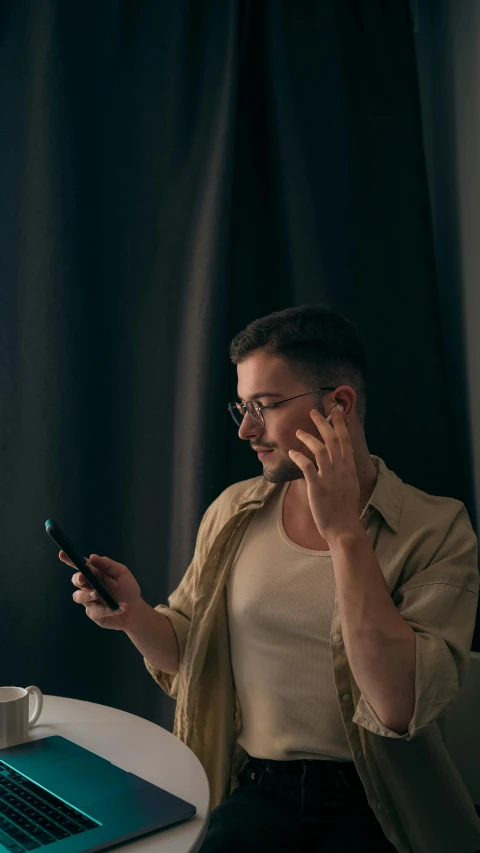 a man talking on a cellphone while sitting at a table