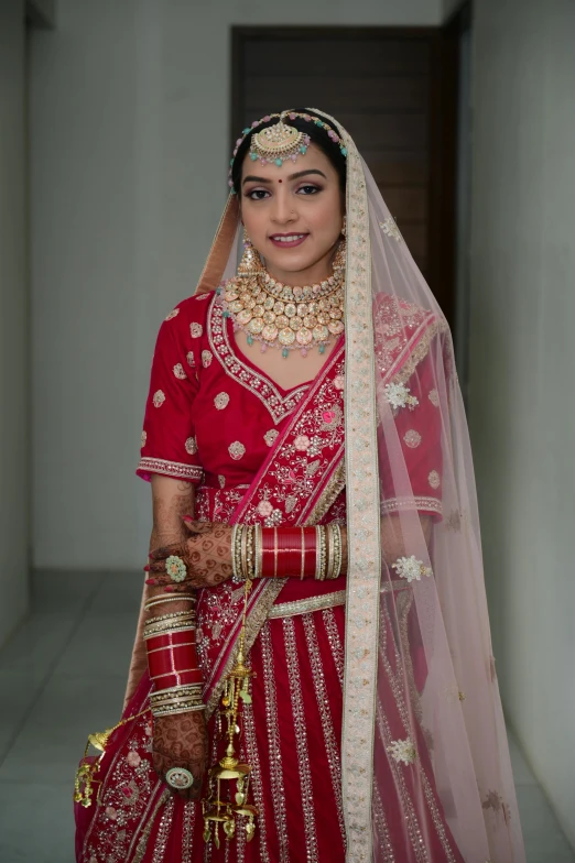 a woman wearing a red wedding gown and heavy make up