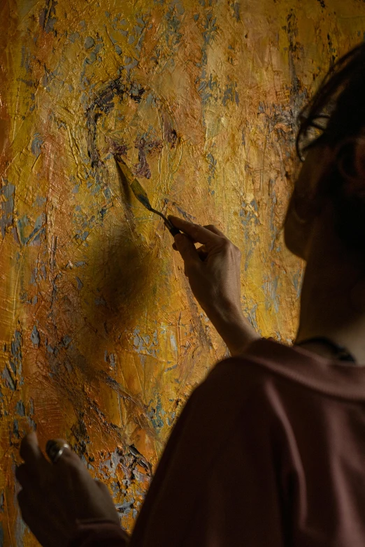 a person uses scissors to paint on a yellow wall