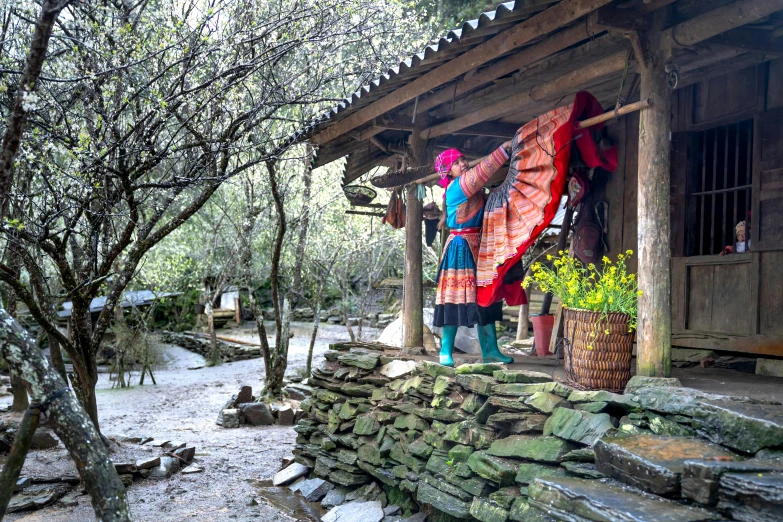 two women are hanging out their clothes outside