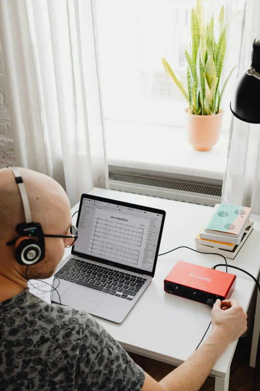 the man is looking at his computer on his desk