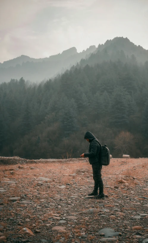 a person wearing a backpack standing in the middle of a field