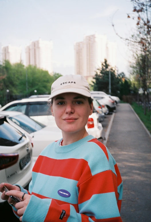a woman in striped shirt standing next to a street