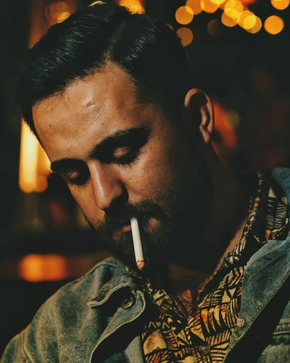 a man smoking a cigarette while wearing a jacket