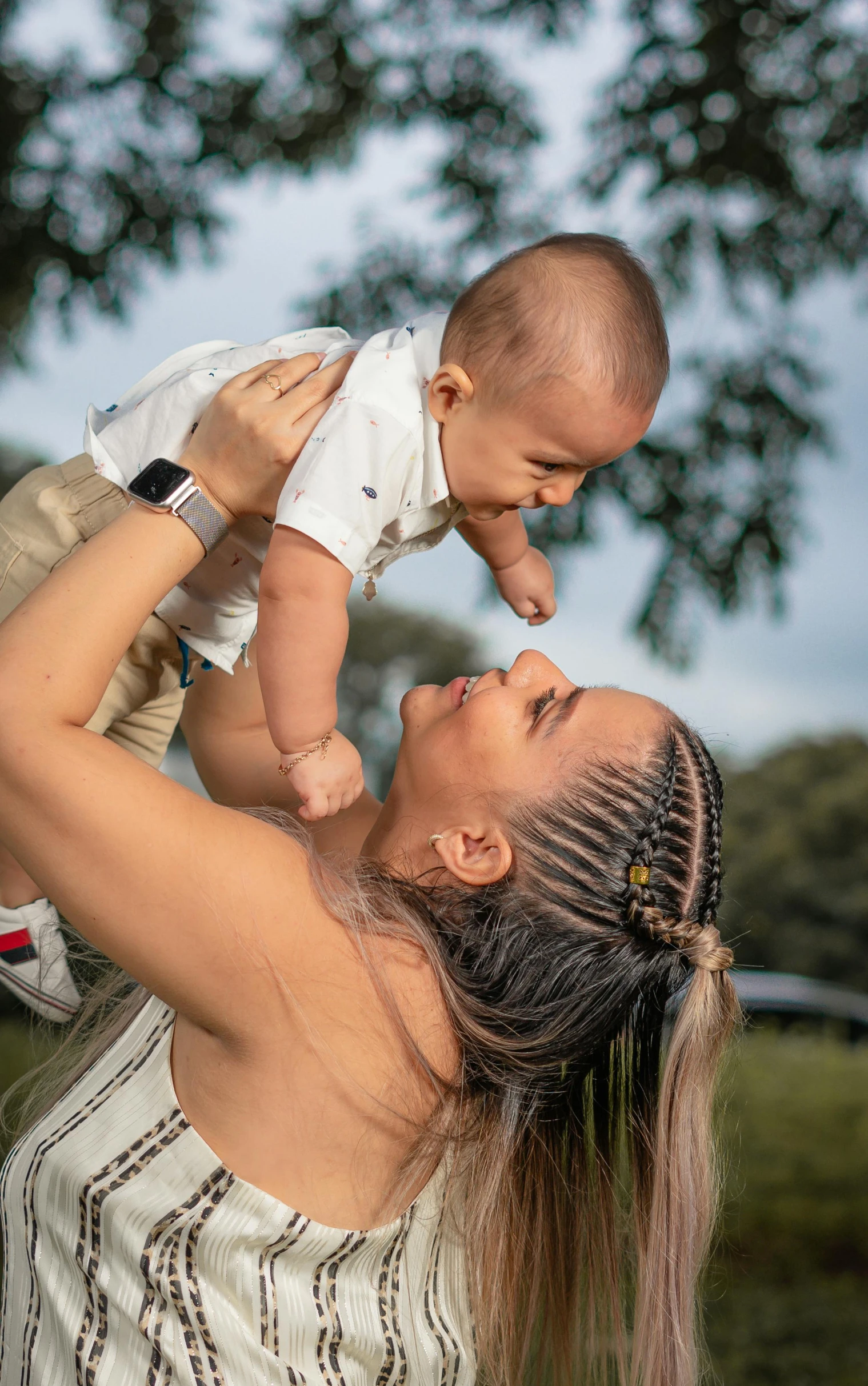 a woman holding a baby over her head