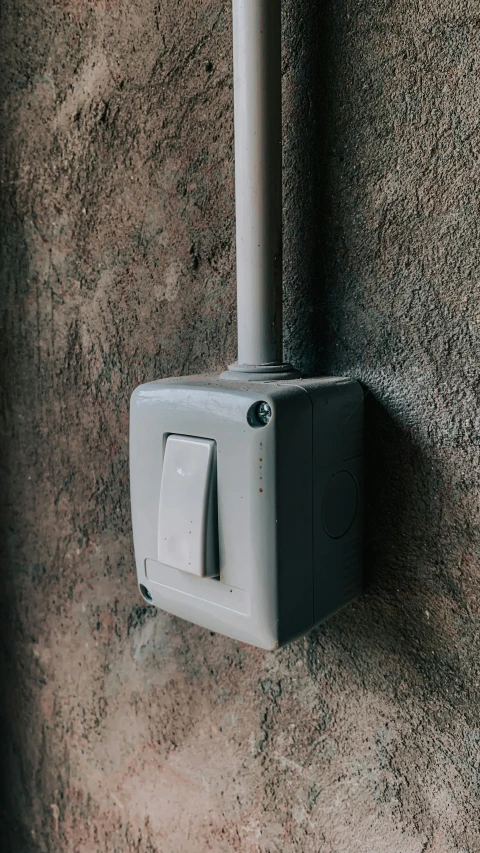 a wall mounted electrical box next to a concrete wall