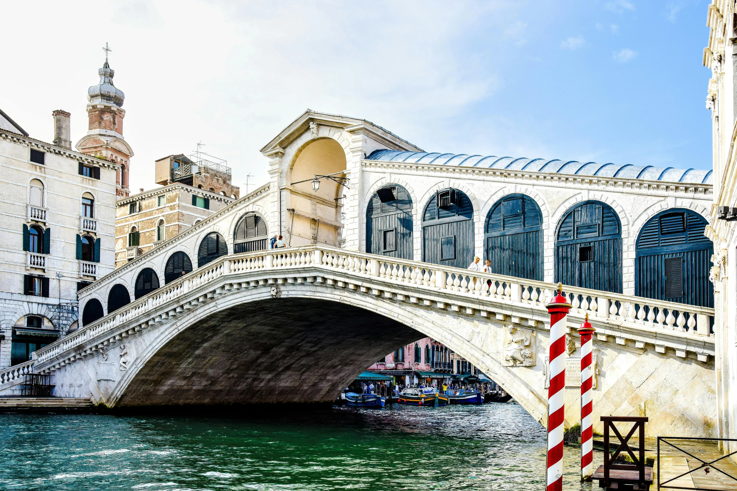 a boat sails under a bridge in front of some buildings