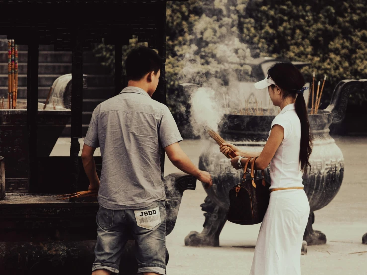 a man and woman are standing in front of a fountain