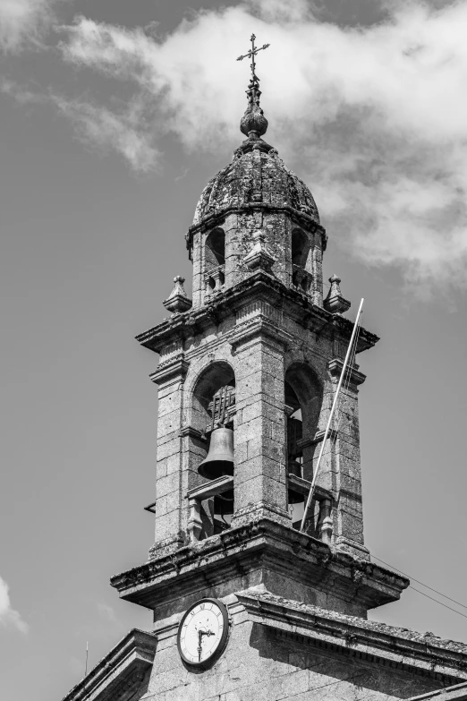 a clock tower with a cross on top of it