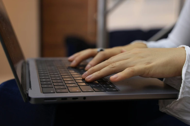 a woman sitting down using a laptop on her lap