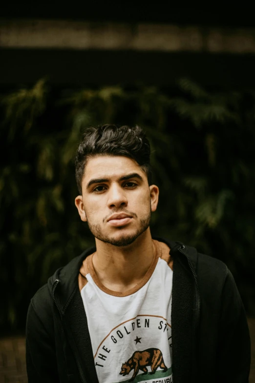 a man standing in front of a bush with a big head