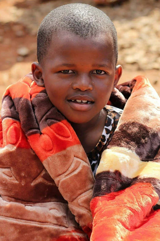 a child with black hair and a striped shirt wrapped around him