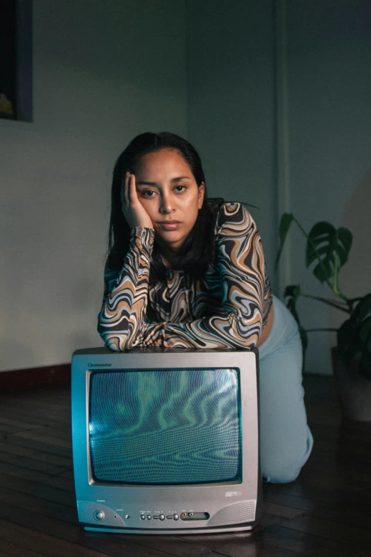 a young lady is sitting at a table next to a tv