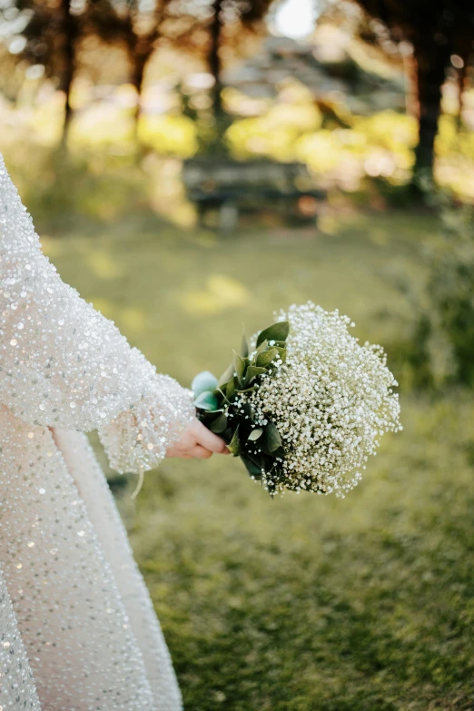 a woman holding a bouquet of flowers in her hand