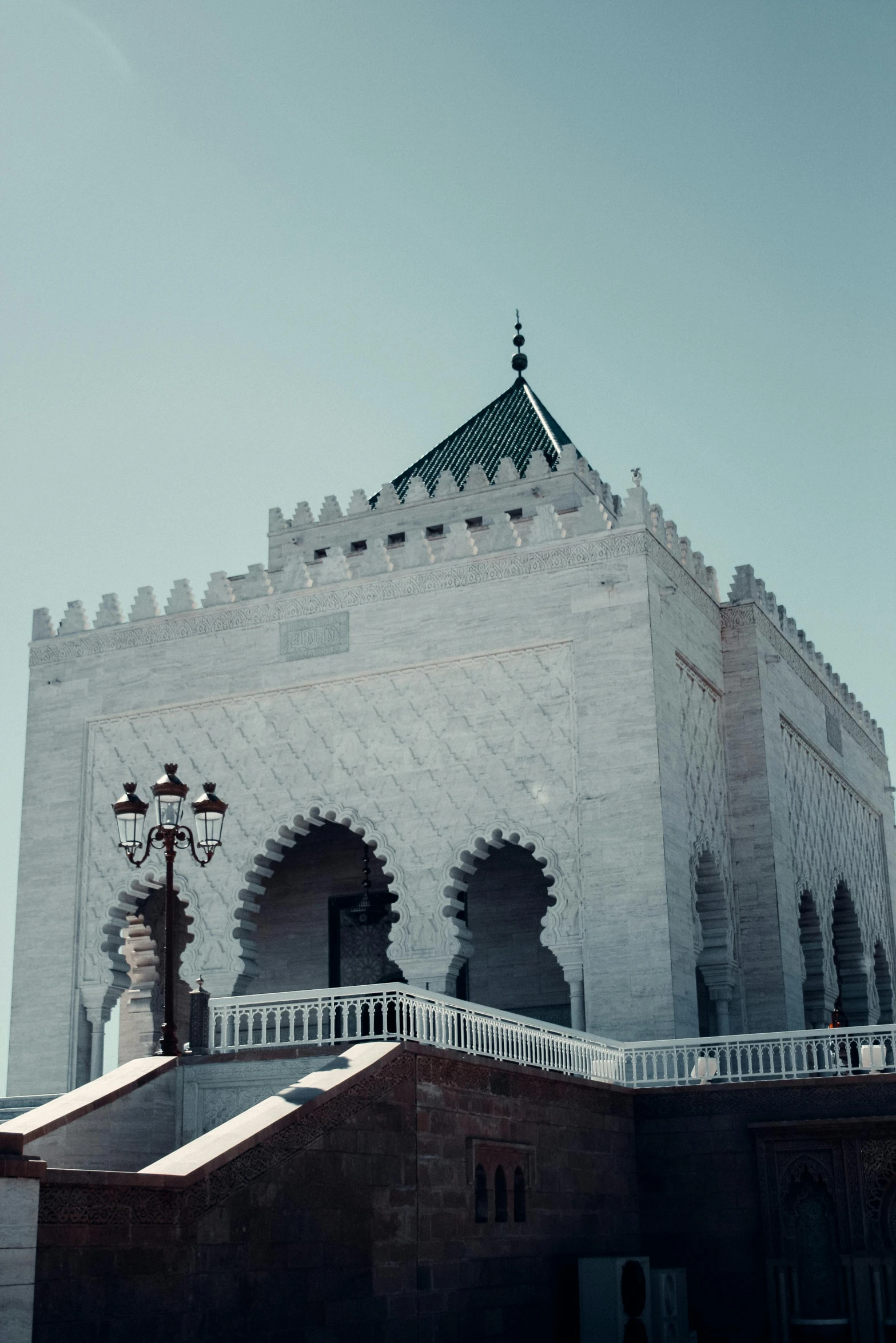 an ornate building on top of a hill under a blue sky